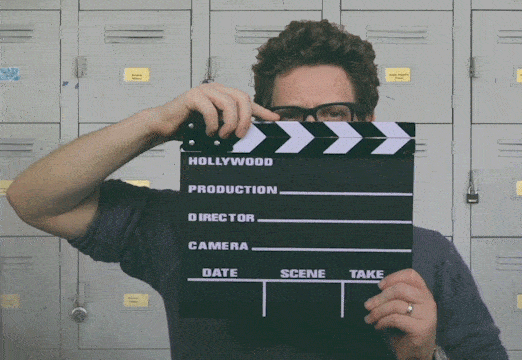 A man is holding a movie clapperboard.