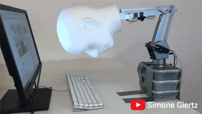 Robot head hitting a computer keyboard