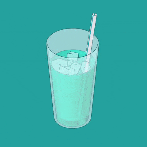 A glass filled with liquid and a straw with ice cubs turning around