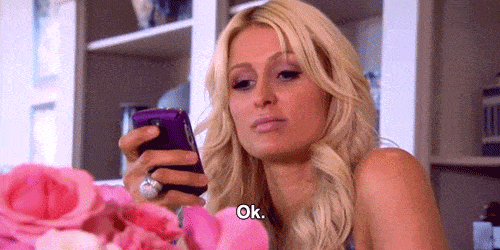 Paris Hilton looking at her mobile saying OK.