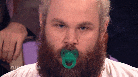 A man has a pacifier in his mouth.