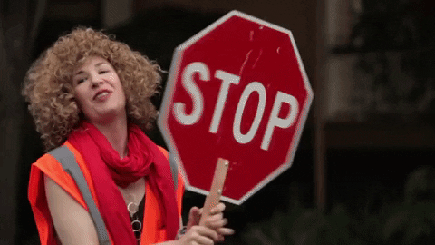 A woman turns a stop sign to "slow."